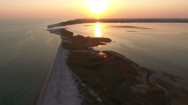 Tiro aéreo de um pôr-do-sol pitoresco na ilha de Dzharylhach cuspo de areia no verão — Vídeo de Stock