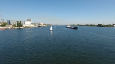 Beyaz bir yat ve Dnipro güneşli bir günde rekabet bir mavna hava atış