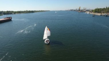 Bir beyaz bir direk hava atış parlak mavi nehir sularında yelken yat