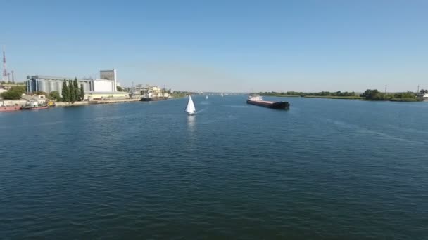 Tiro aéreo de um iate branco e uma barcaça competindo no Dnipro em um dia ensolarado — Vídeo de Stock