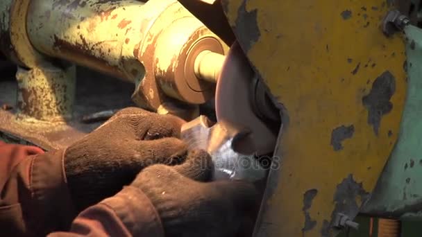 Некоторые рабочие шлифуют шестиугольный металлический слиток во время работы шлифовального станка — стоковое видео
