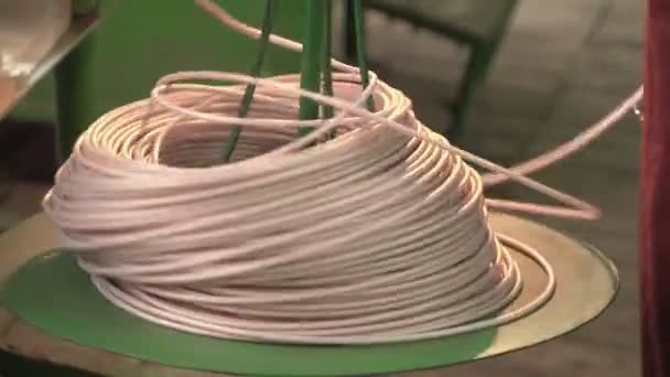 Some plastic cord on a reel spins slowly in a workshop at a plant — Stock Video