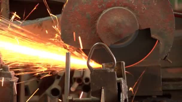 Una sierra circular de metal corta una lámina de metal con una corriente de destellos en un taller — Vídeos de Stock