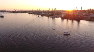 Hava atış grand Dnipro, yelkenli yat ve gün batımında modern setin. Sürükleyici bir kuş bakışı bir yelkenli yat ve yaz aylarında gün batımında endüstriyel dolgu ile pitoresk Dnipro.