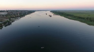 Pitoresk Dnipro yüzen gemiler ve teknelere yaz aylarında hava atış. Harika bir kuş bakışı, geniş yeşil nehir ve kayan ile Dnipro uzakta bir muhteşem gün batımı gemi. Gökyüzü harika.
