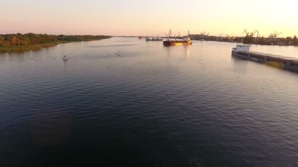 空中拍摄的移动驳船和游艇在灿烂的 Dnipro 在夏季日落 一个令人鼓舞的鸟瞰的浮动游艇和驳船上的平滑表面的 Dnipro 在一个美丽的夕阳夏季 — 图库视频影像