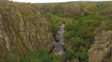 Mistik bir kanyonun dibinde büküm bir gizemli kuş bakışı kara Nehri yeşillik yamaları ile kaplı ve kaya bölünmüş