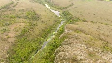 Orada yaz aylarında hafif kahverengi taş ile kaplı yüksek tepeler arasında akan dar bir nehir ile bir curvy Uçurumu'nun şaşırtıcı bir görünümü