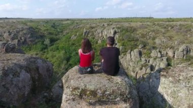 Çarpıcı kuşbakışı göz görüntüsünü genç bir adam ve kız arkadaşı oturan bir güneşli bir günde Ukrayna'da bir dağda taş yığını bir
