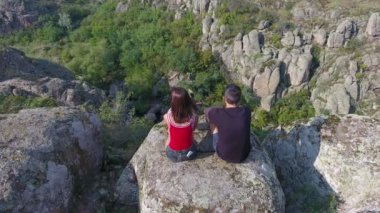 Etkileyici bir kuşbakışı göz görüntüsünü bir genç adam ve sevgilisi oturan bir güneşli bir günde Ukrayna'da bir dağda taş yığını bir