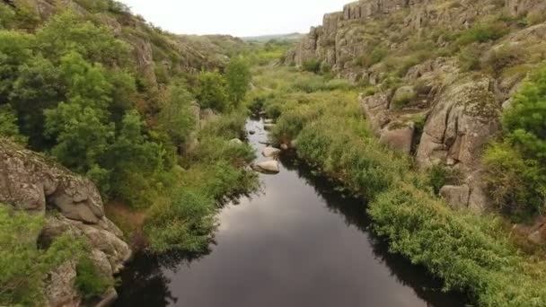 ウクライナの大きな石とロッキー山脈の峡谷を見ておとぎ話に流れる黒い川の鳥瞰図 — ストック動画