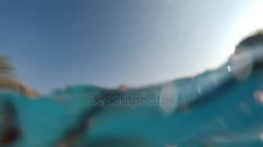 Mutlu bir kadın kadar alacakaranlık arka planda bir palm ile Akdeniz'in mavi sularında atlama optimisticy görünümünü.