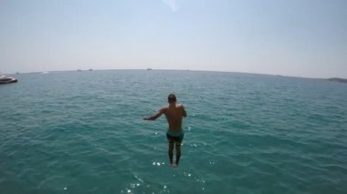 Çok renkli şort parlak mavi sularda bir Türk tatil yaz yavaş atlama sportif bir erkekte etkileyici bir manzara