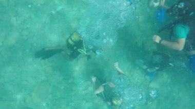 Kemer, Turkey - 18 Temmuz 2017: Akdeniz altındaki bakmak ve birçok hava kabarcıkları slo-mo mavi sularda gönderecek üç tüplü dalgıçlar etkileyici bir manzara