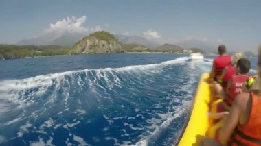 Kemer, Turkey - 19 Temmuz 2017: sonra Türkiye'de bir motoboat güneşli bir yavaş hareket büyük bir sarı muz sürme turist çığlık çığlığa bir iyimser görünümü. 