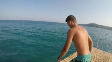 Güneşli bir yaz slo-mo Akdeniz sularında atlar sportif genç bir adam şortla etkileyici bir manzara 