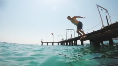 Orta yaşlı bir adamın kafa ilk Türk bir tatil güneşli bir günde slo-mo turkuaz deniz sularda dalış çarpıcı bir görünüm