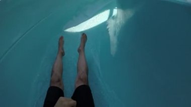 Genç bir adam aşağı kayan bir aquapark ve güneşli bir yaz aylarında Türkiye'de bir selfie yapma etkileyici bir manzara. 