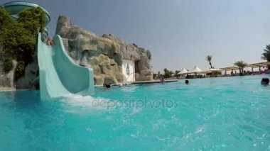 Kemer, Türkiye - Temmuz 18, 2017:A bir Türk aquapark yüksek mavi slayda yaz aylarında Taşınılan bir kadın komik görünümü. Mavi suları iyi bak.  