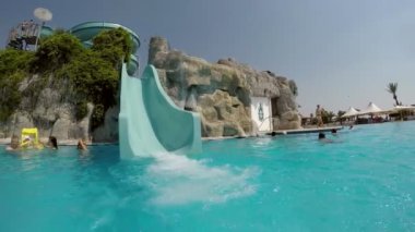 Kemer, Turkey - 18 Temmuz 2017: Bir çocuğun bir yüksek mavi slayttan bir Türk aquapark yazında aşağı hareket heyecan verici bir görünüm. Turkuaz rengi iyi bak.  