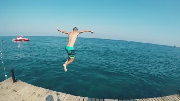 Впечатляющий Вид Молодого Человека Разноцветных Шортах Прыгающего Ногами Первым Бирюзовых — стоковое видео