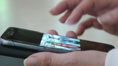 Nikolaev, Ukrayna - 1 Kasım 2017: onun smartphone hakkında biraz bilgi arayan bir el orijinal bir bakış. O ekran dokunur ve çeşitli resimleri görünüyor.