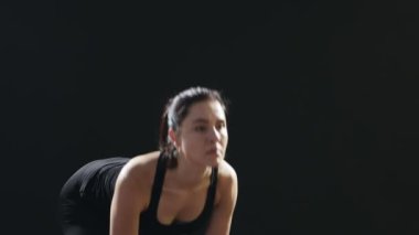 Fitness Eğitmeni ileri ileri metalik dumbbells ile virajlı ve ileri bir spor salonunda kendini eğitimi sırasında görünüyor ince bir kadın ilham verici bir görünümünü sportif bir spor salonunda metalik dumbbells ile eğiliyor