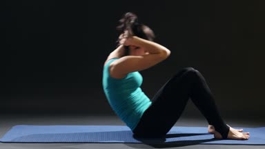 Sportif kadın bir yoga mat üzerinde yatıyor ve crunches yapmak için vücudunu yükseltir. Onun basın trenler bir mindere yalan, vücudu yükselterek, kollarını tutmak onu ense genç bir kadın öğretici bir bakış.         
