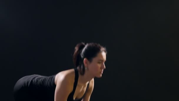运动妇女在一个体育的健身房里用金属哑铃向前弯曲一个细长的女人的一个令人兴奋的看法 弯曲前金属哑铃 并期待在训练自己在一个体育健身房 — 图库视频影像
