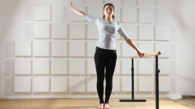İnce kadın bir kenara ahşap kol demiri bir spor salonunda aktif olarak tutarken görevini yerine getirmektedir. Bir çubuk anlamına gelir ve bu tutar bir sportif kadın heyecan verici bir bakış. Aynı zamanda o bir kenara virajlı ve vücudu tren kadar elini yükseltir