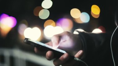 Adamın elleri bir semt kışın cadde üzerinde bir smartphone ekrandaki bilgileri cep telefonunu ekran dokunaklı ve bir şehir kış akşamları sokak hakkında biraz bilgi arayan erkek eller özgün bir closeup aramak.