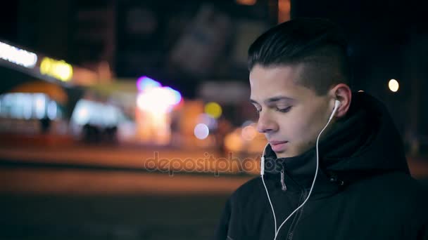 Young Man Waits His Girlfriend Earbuds Ears City Street Winter — Stock Video