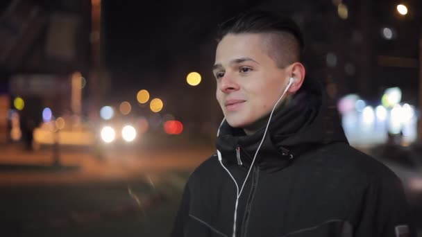 Joven Sonríe Escucha Una Música Auriculares Una Calle Ciudad Invierno — Vídeos de Stock