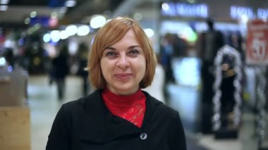 Sarışın kadın bir alışveriş merkezinde mutlu olmak Noel hediyeleri tam bir yün Noel hediyeleri tam bir alışveriş merkezi içinde mutlu bir sarışın kadın şaşırtıcı bir görünüm durumda. O Noel ruhu tam olarak gülümsüyor