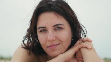 Esmer kadın Karadeniz Sahil ve gülümsüyor slo-mo Karadeniz kıyısında yalan söyleyen bir genç kadına romantik bir bakış içinde romantik ve gülümsüyor üzerinde romantik parıldıyor ile güzel gözlerinde yaz slo-mo yatıyor