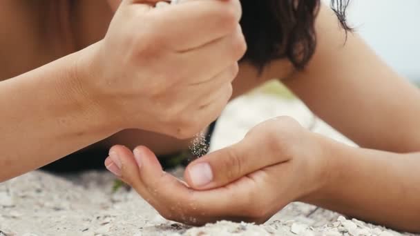 조개와 해변에 Slo 여자의 모래의 Handfuls을 아래에 연안에 슬로우 모션에서 — 비디오