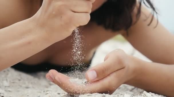 女性双手在夏季黑海海滩上用贝壳筛沙子斯洛伐克 莫一个令人兴奋的特写 年轻女子的手拿起沙子 倾泻而下 在黑海沿岸在夏季慢动作 — 图库视频影像