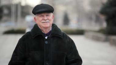 Cesur komuta sizde bir şehir sokak üzerinde duran bir gri saçlı adamın bir deri kürk ve deri şapkası Kış A neşeli görünümünde bir sokakta bir deri kürk ceket gülümsüyor ve gülümsüyor yeni yıl arifesi
