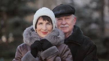 Mutlu orta yaşlı bir kadın ve üst düzey kocası bir semt kışın cadde üzerinde durmak şanslı bir iyimser bir bakış evli çift birlikte kışın güneşli bir Noel ruhu tam olarak bir şehir sokakta gülümseme ve stand