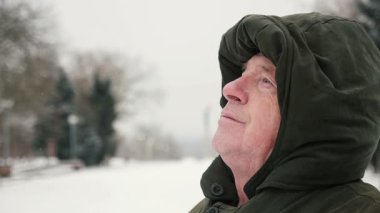 Akıllı komuta sizde oturur ve kış slo-mo gençliğinde hatırlar. Bir üst düzey gri saçlı adam bir anorak kukuleta ile çarpıcı bir görünüm kafasında bir sokak bankta oturur... ve yavaş kışın görünüyor.