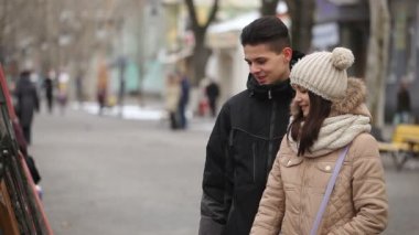 Mutlu adam ve onun bal sokak sanat galerisinde resimlerle kışın çok güzel bir genç çift iyimser bir bakış bak bakarak ile resimler üzerinde bir park alanı kışın duruyor. Güzel bir kız bir resme Puan.