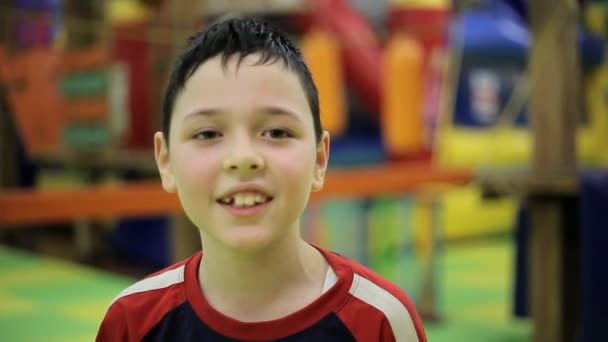 Μικρό Αγόρι Εννέα Ετών Στέκεται Και Χαμόγελα Ευτυχώς Ένα Γυμναστήριο — Αρχείο Βίντεο