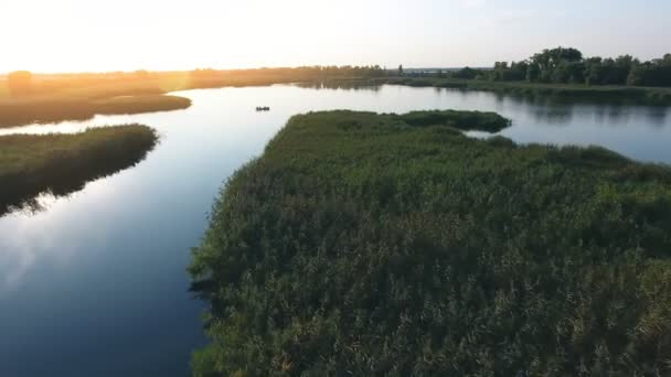 空中拍摄的 Dnipro 河岛和流入灿烂的夕阳在夏天的 Dnipro 河流入和小岛覆盖的芦苇 百合和芦苇在波光粼粼的夏季日落的一个奇妙的看法 — 图库视频影像