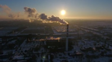 Beyaz ile yüksek sıcak gaz baca hava atış kışın günbatımında bir kuş bakışı bir büyük kazan baca, beyaz bir duman akışı ile kışın muhteşem bir günbatımı, duman. Cityscape kentsel ve ince