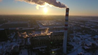 Beyaz ve kırmızı sıcak gaz baca beyaz ile hava atış kışın gün batımında gökyüzü scrappichimney bir kuş bakışı manzaralar duman yavaş akışı ile kışın harika bir gün batımı, duman. Cityscape karlı.