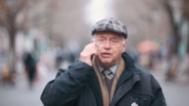 Yünlü bir düz kapak üst düzey bir erkekte yürür ve bir arka sokakta sonbaharda çağırır. Yaşlı bir adam bir özgün görünümüne bir siyah zipup ceket ve yünlü bir düz kapak giymiş. Biri sonbaharda çağıran bir park sokak yürüyor. 