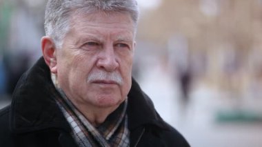 Gri başlı üst düzey adam damalı bir eşarp ile sokakta sonbaharda siyah ceket, kareli siyah beyaz kaşkollu güneşli bir günde bir park sokakta duran cesur bir gri saçlı adam etkileyici bir manzara sahanın 