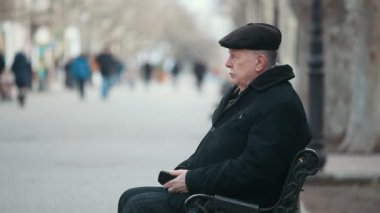 Yaşlı, bilge bir adam bir bankta oturur ve bir park sokak hayatında hakkında akıllıca komuta sizde bir siyah ceket ve sonbaharda bir park sokakta oturan bir düz kapak görkemli profil görünümü sonbaharda düşünüyor. O uzun hayatı hakkında düşünüyor