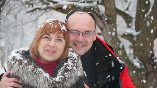 Счастливый Муж Обнимает Свою Блондинку Жену Шубе Падающим Снегом Парке — стоковое видео