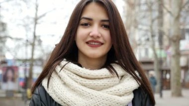 Çekici kız bir şehirde kış aylarında sokak anlamına gelir. O sevinçle çekimde şık bir parka kadar gevşek saçlı bir üst modeli kız gülümsüyor ve kışın sokak bir şehirde beyaz kaşkollu duruyor. O içtenlikle gülümsedi.
